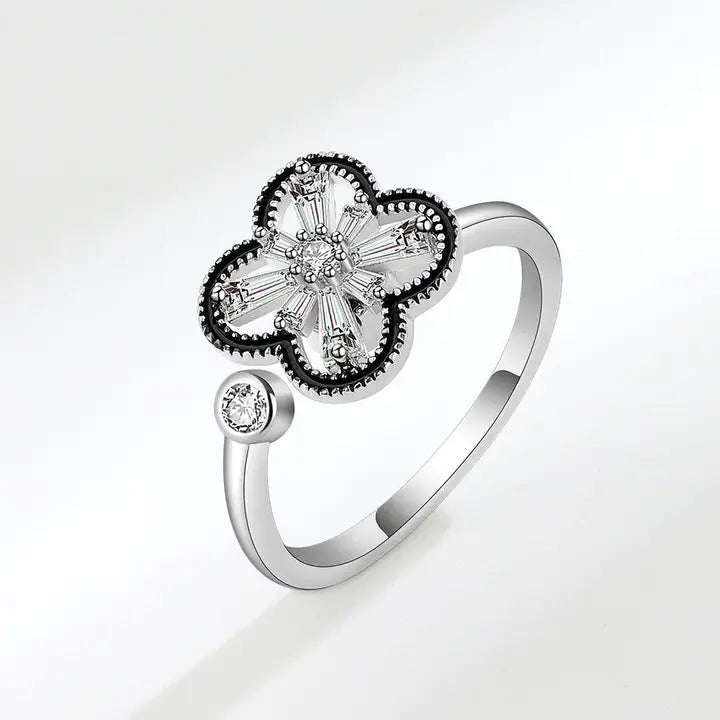 Silver ring with a clover-shaped design on a light gray background