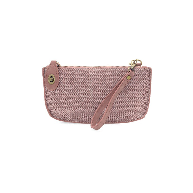 Pink woven handbag with a strap on a white background