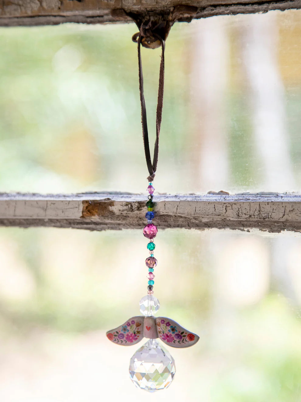 Decorative hanging ornament with colorful beads and a glass ball on a branch.