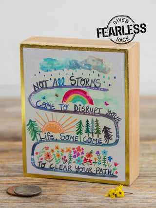 Decorative wooden box with motivational quote and illustrations on a wooden surface.