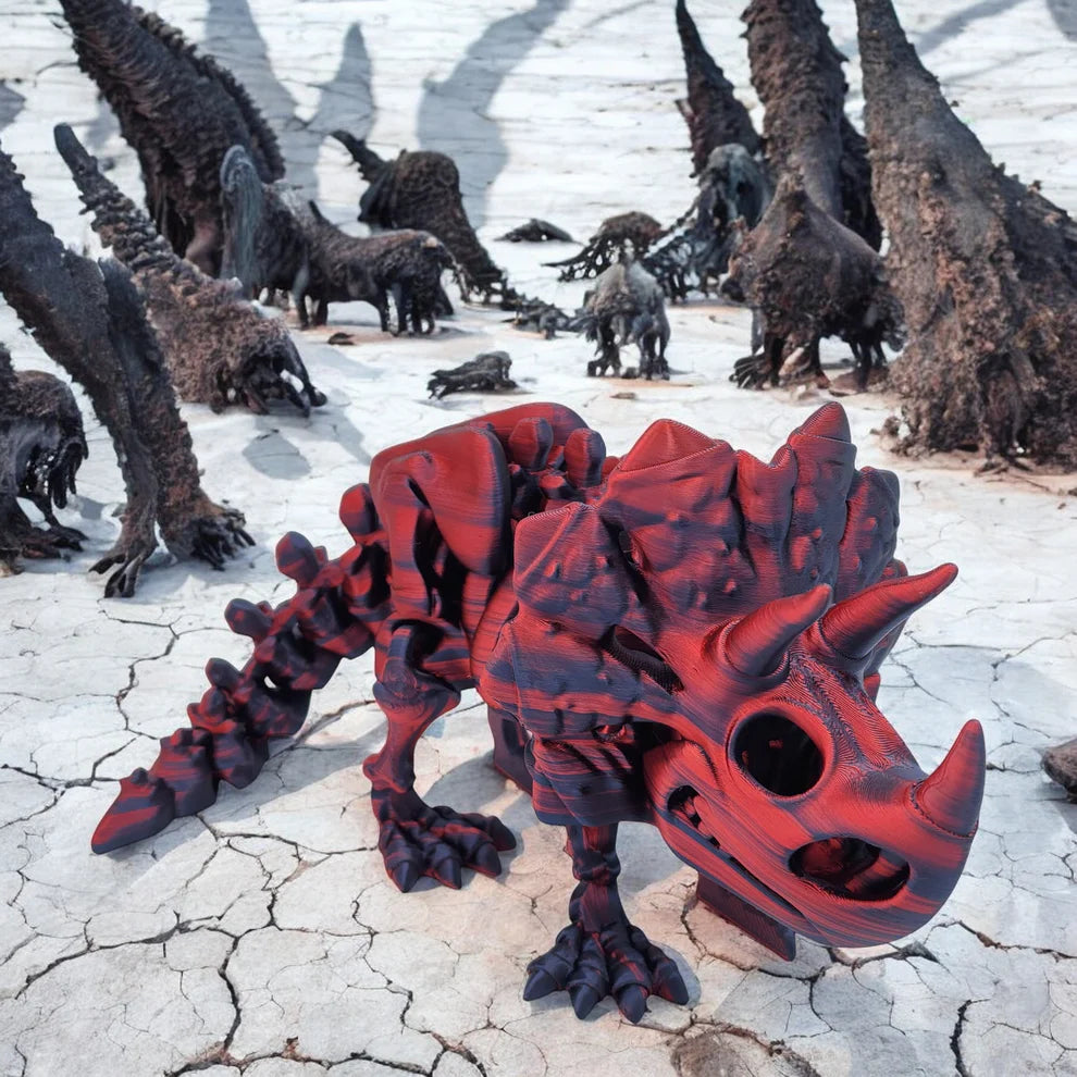 Red and black dinosaur skeleton model on a cracked surface with other similar models in the background.