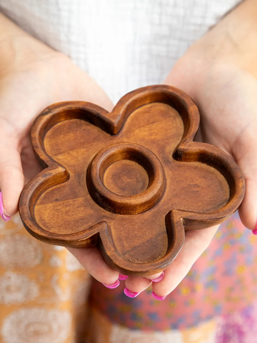 Wooden fidget spinner held by hands with a blurred background